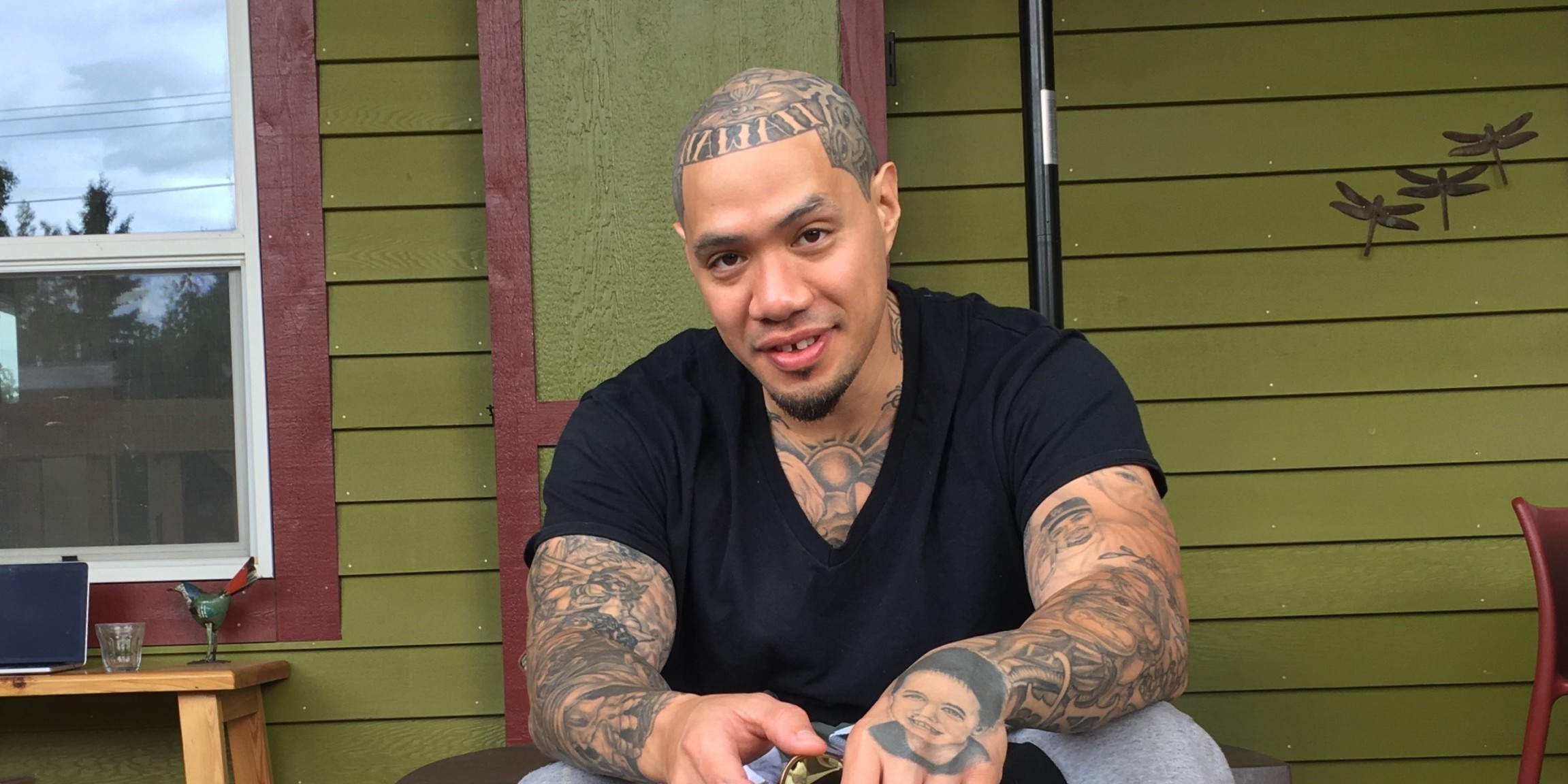 tatooed man smiling at camera